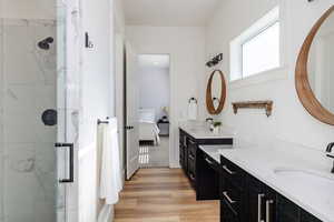 Bathroom with a shower with door, vanity, and wood-type flooring