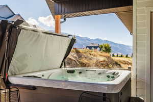 View of patio featuring a hot tub and a mountain view