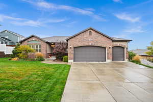 View of front of property with a front yard and a garage