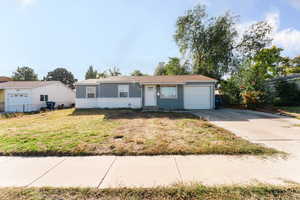 Ranch-style home featuring a garage and a front lawn