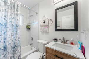 Full bathroom with vanity, shower / tub combo, and toilet