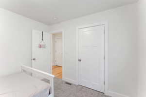 Bedroom featuring light carpet