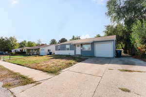 Ranch-style house featuring a front yard and a garage