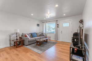 Living room with a textured ceiling and wood-type flooring