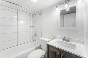 Full bathroom featuring toilet, tiled shower / bath, and vanity