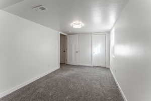 Carpeted spare room with a textured ceiling