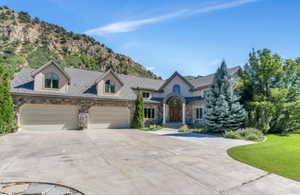 French country inspired facade with a garage and a mountain view