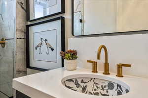 Details with vanity and a tile shower