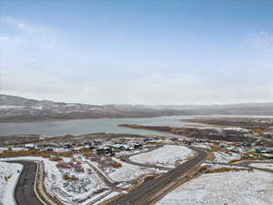 Snowy aerial view featuring a water and mountain view