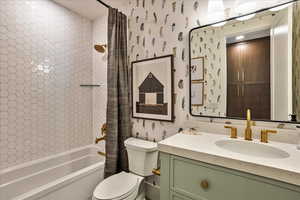 Full bathroom featuring vanity, shower / bath combo with shower curtain, and toilet