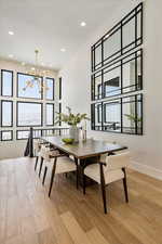 Dining space with light hardwood / wood-style flooring and an inviting chandelier