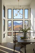 Dining space with a notable chandelier, a mountain view, and hardwood / wood-style flooring