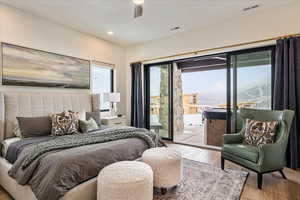 Bedroom featuring light hardwood / wood-style floors, a mountain view, access to exterior, and ceiling fan