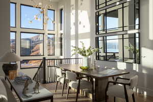 Dining room featuring a high ceiling, wood-type flooring, and an inviting chandelier