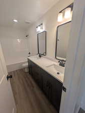 Full bathroom featuring vanity, toilet, wood-type flooring, and bathing tub / shower combination