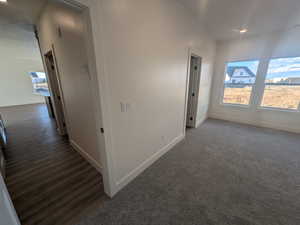 Hallway with dark hardwood / wood-style flooring