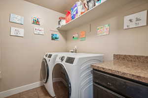 Laundry room featuring washer and dryer, a textured ceiling, and light tile patterned floors