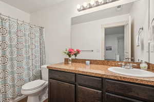 Bathroom with vanity, toilet, and a shower with curtain