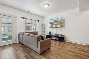 Living room with a healthy amount of sunlight and wood-type flooring