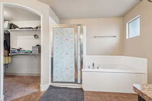 Bathroom featuring vanity, tile patterned flooring, and plus walk in shower