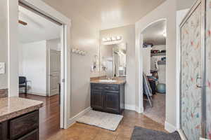 Bathroom with ceiling fan, a textured ceiling, walk in shower, vanity, and tile patterned floors