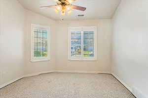 Carpeted spare room featuring ceiling fan