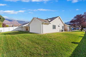 View of property exterior featuring a mountain view, a lawn, and cooling unit