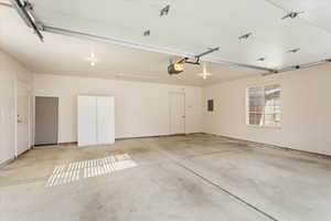 Garage featuring a garage door opener and electric panel