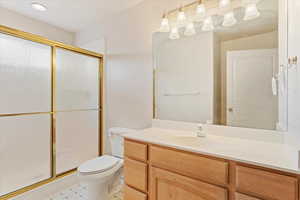 Bathroom featuring vanity, toilet, tile patterned floors, and walk in shower