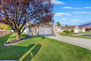 Ranch-style home featuring a front yard and a garage