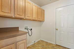 Washroom featuring cabinets, washer hookup, and electric dryer hookup