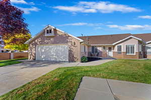 Single story home featuring a front yard and a garage