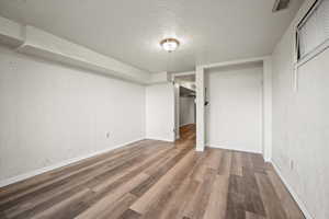 Unfurnished bedroom with a closet, hardwood / wood-style floors, and a textured ceiling