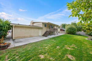 Rear view of property with a patio area and a lawn