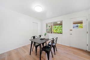 Dining area with light LVP wood-style flooring and backyard access