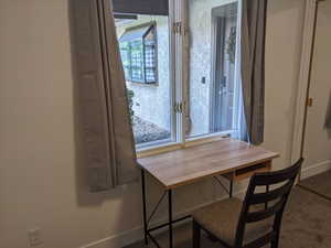 Main level second bedroom featuring window looking out to the entrance patio