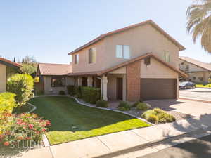 View of front of property with a front yard and a garage