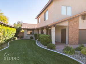 Front lawn featuring a yard and a garage