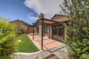 Rear view of house with a patio and a lawn