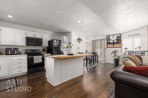 Kitchen featuring wooden counters, black appliances, white cabinetry, a textured ceiling, and dark hardwood / wood-style flooring