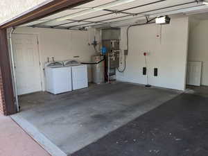 Garage featuring a WIFI enabled garage door opener, water heater, heat pump furnace/AC, and separate washer and dryer