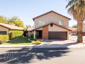 View of front of home with a front yard and a garage