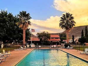 Pool at dusk featuring a patio area