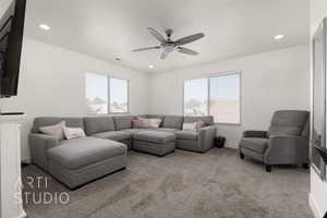 View of  living room, 65" television, hideaway ottoman, fireplace and ceiling fan and plenty of natural light