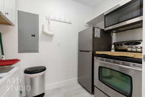 Kitchen featuring white cabinets, electric panel, stainless steel appliances, and light tile patterned floors