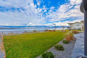 Fenced backyard with a water and mountain view