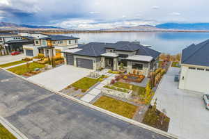 Prairie-style home featuring a water and mountain view, a garage, driveway, and stone siding
