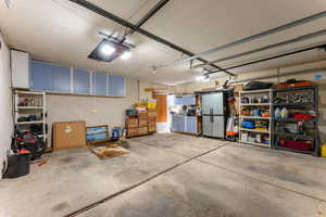 Garage with a garage door opener and stainless steel fridge