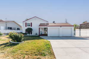 View of front of property with a front lawn and a garage