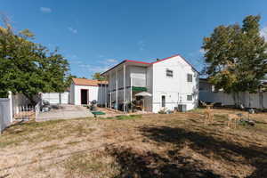 Rear view of property with a storage unit, a yard, central air condition unit, and a patio area